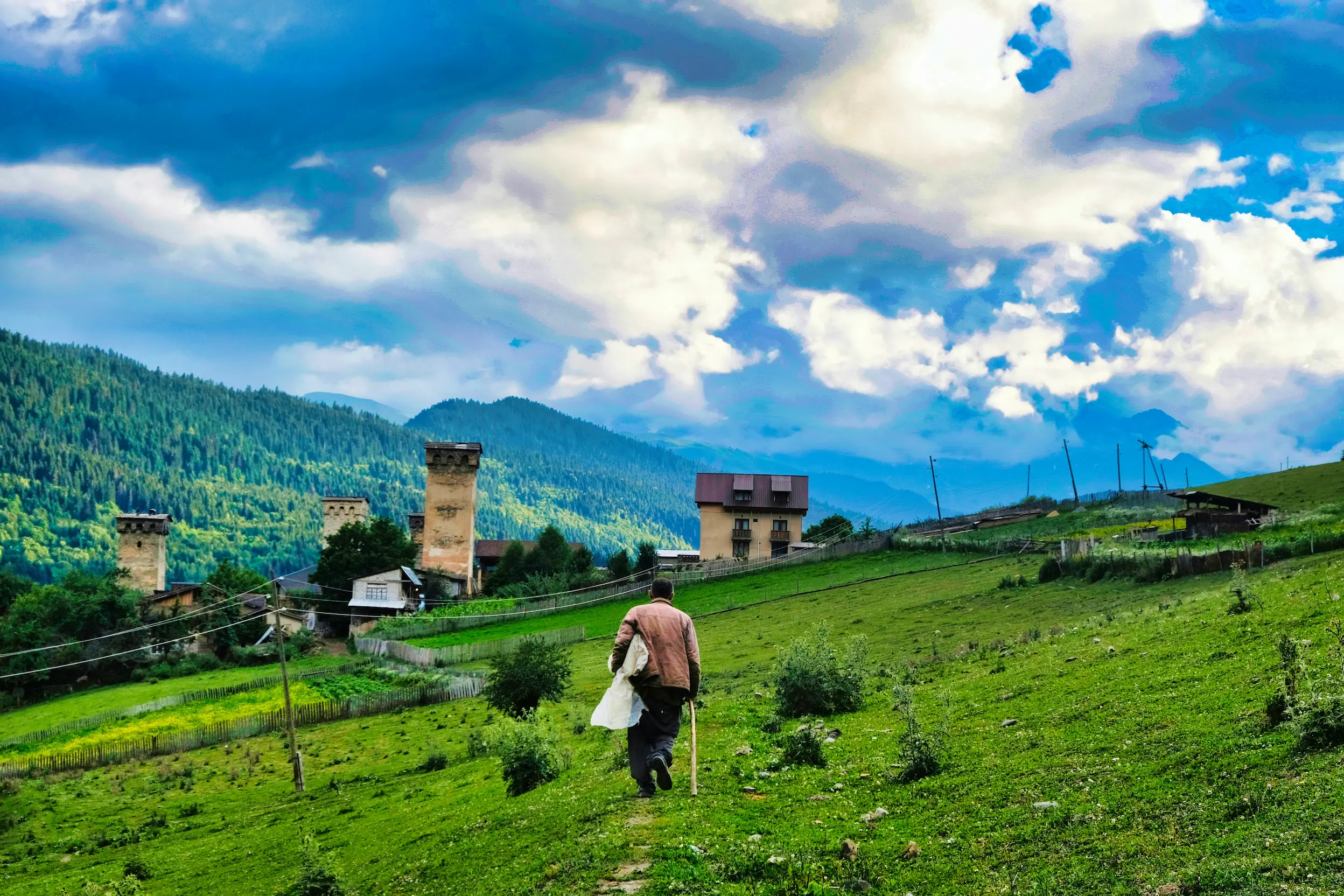 Villager walking on a mountain trail towards village of Ushguli